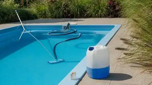Cleaning equipment beside a crystal clear swimming pool