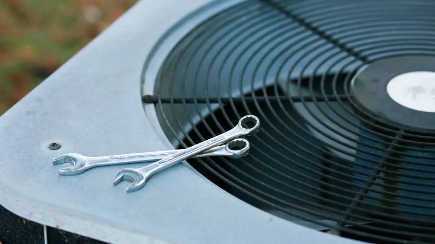 Two wrenches resting on an air conditioning unit